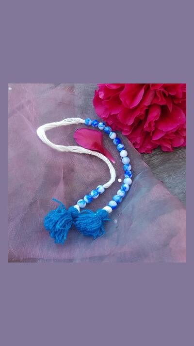 Prayer bead counter in a blue and white bead bag