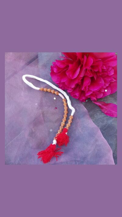 Prayer bead counter in a brown bag, with carved beads